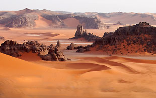 Riesige Dünen umspülen die Felstürme bei Tin Merzouga, Tadrart, Algerien